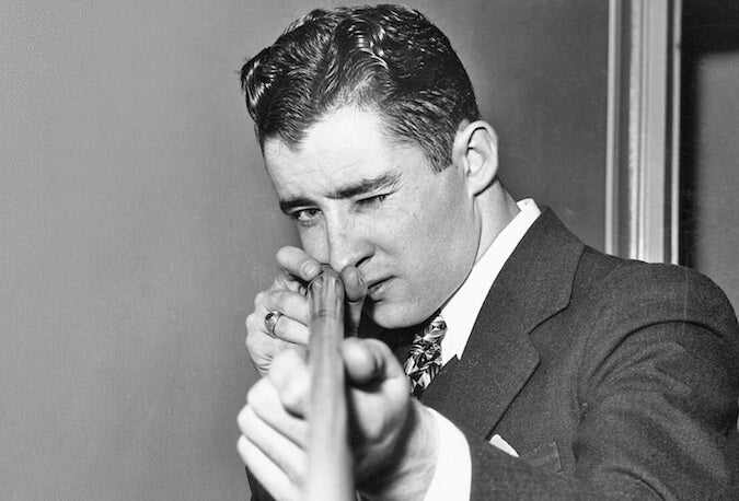 Black-and-white portrait of Willie Mosconi holding a pool cue.